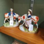 A pair of 19th Century Staffordshire figurines with cowman and milk maid attending cows (as found)