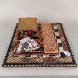 A hardstone chess board together the three light wood examples, two wooden cribbage boards,