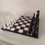 An ornate hardstone chess set with hardstone board