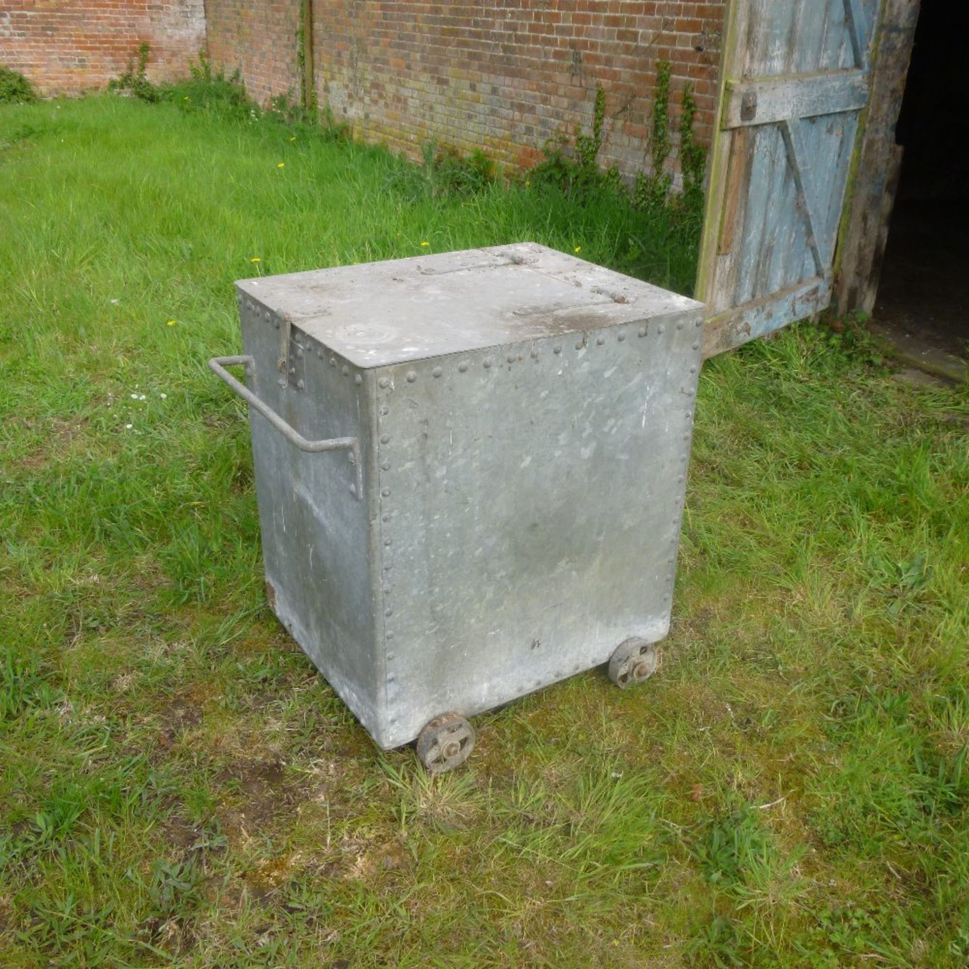 Galvanised feed bin on iron wheels, width 63cm, depth 77cm, height 82cm, in good condition.