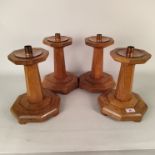 A set of four oak candlesticks with copper sconces,