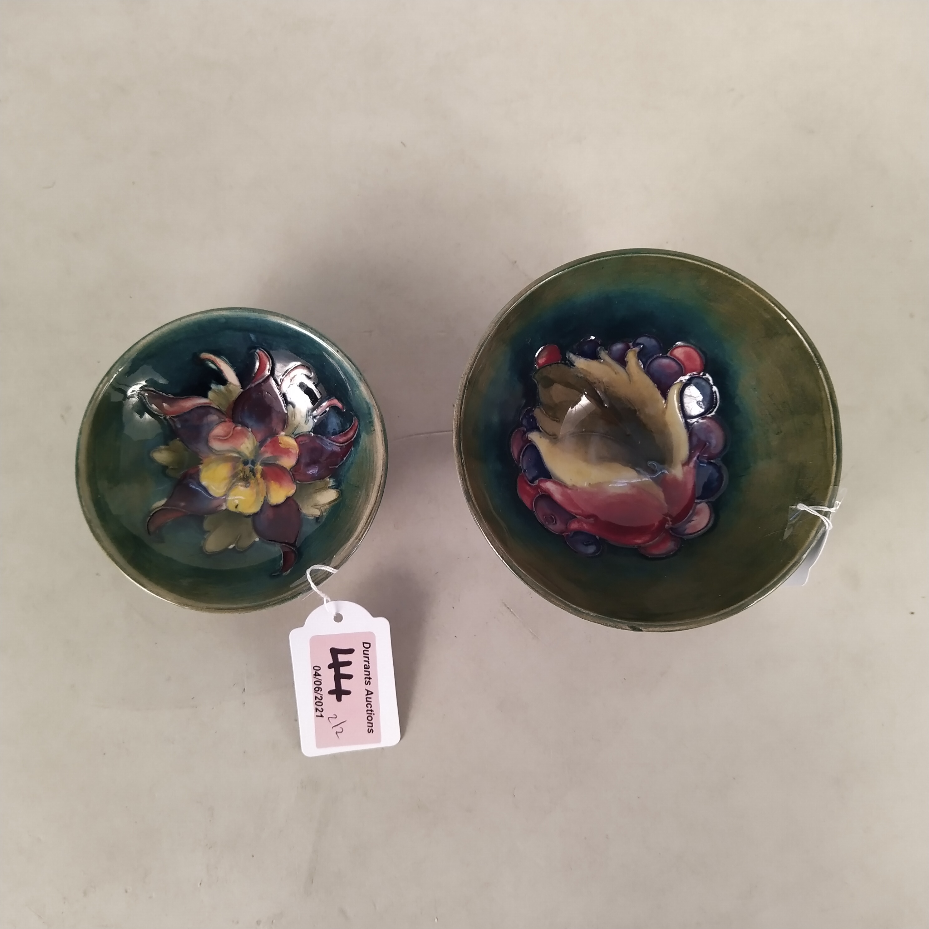 Two Moorcroft small dishes, one bearing the green W Moorcroft signature,