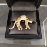 A 9ct gold leopard form brooch set with rubies, sapphires and diamonds,