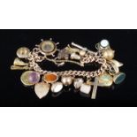 A 9ct gold charm bracelet with twenty one charms including a half sovereign, compass, swivel fob,