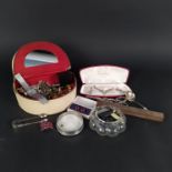 A cream jewellery box with costume jewellery including brooches, necklaces, rings,