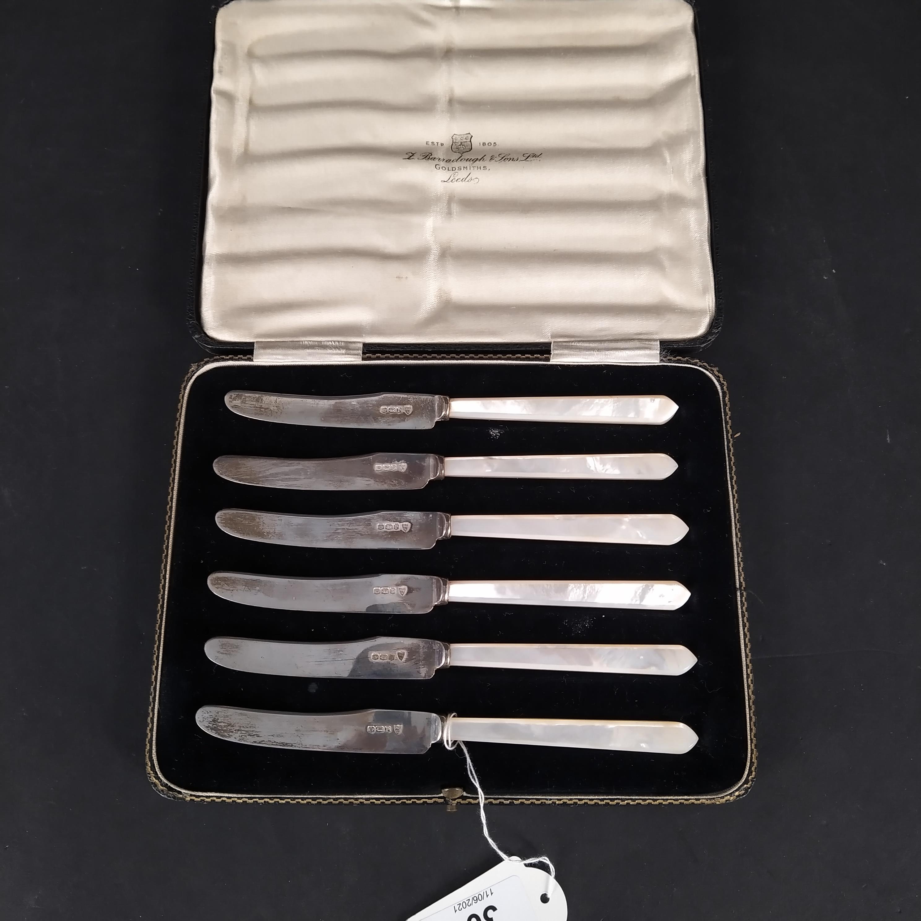 A cased set of six silver bladed mother of pearl handled butter knives,