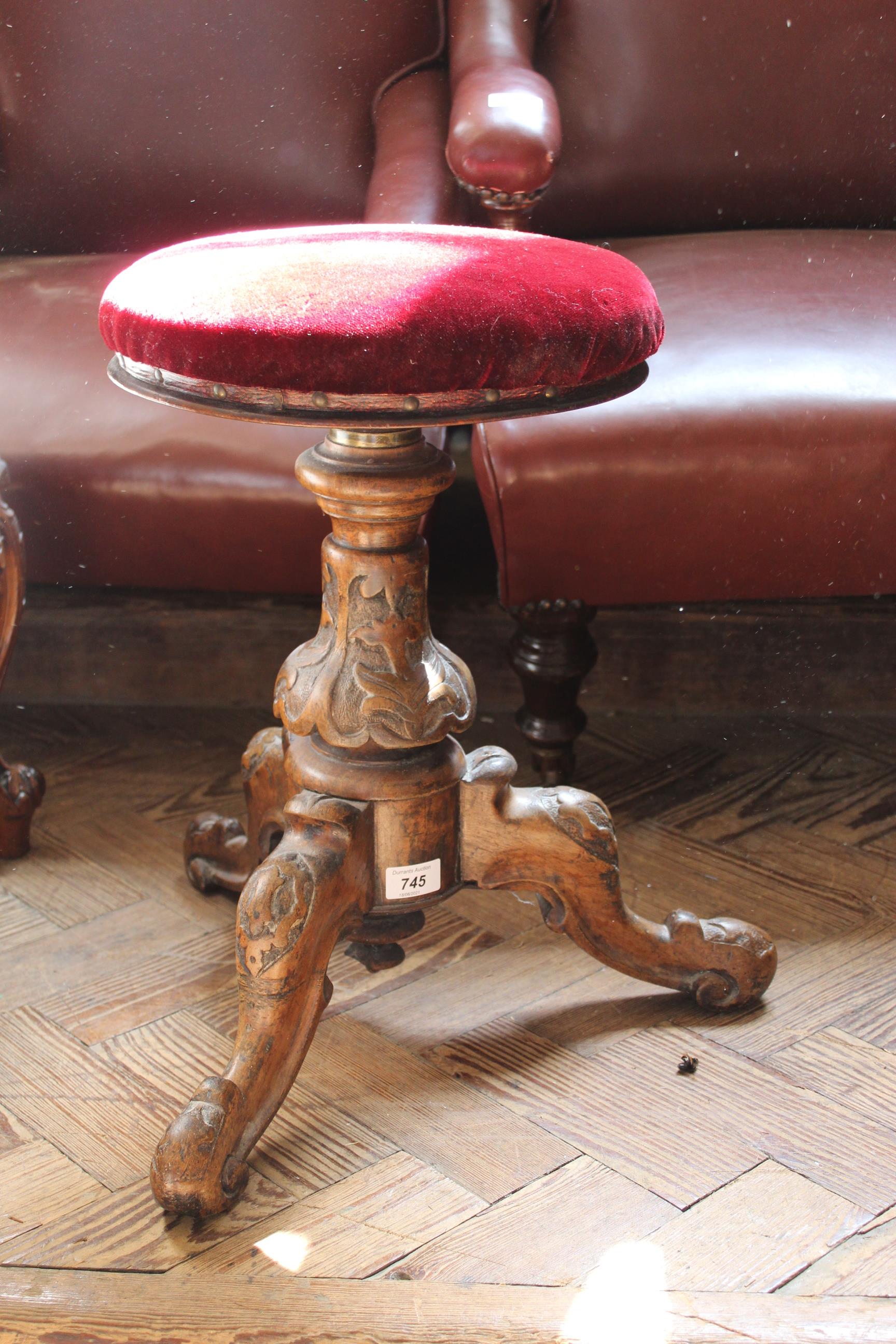 A late 19th Century carved walnut rise and fall upholstered stool