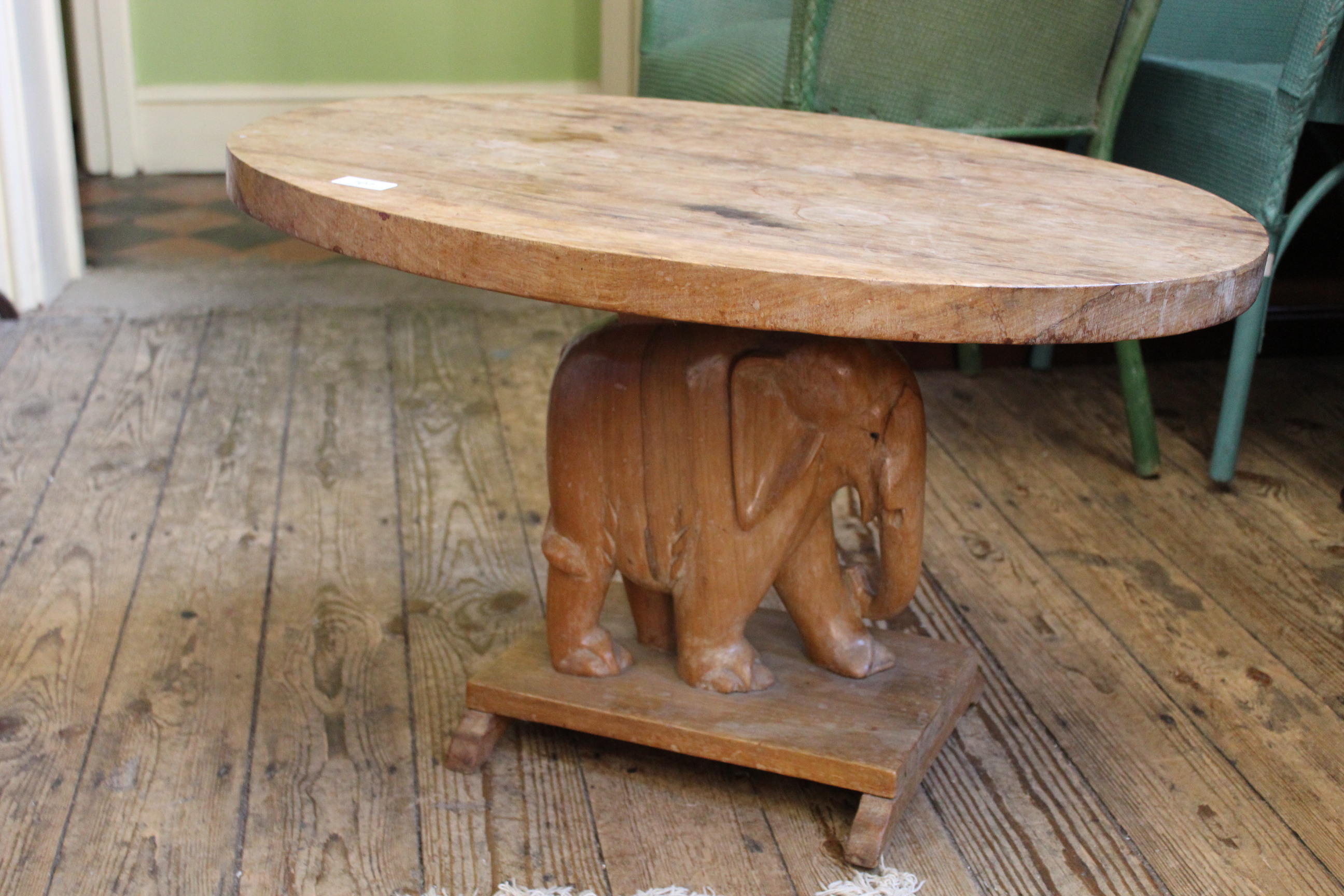 An oval African carved hardwood table with carved elephant support