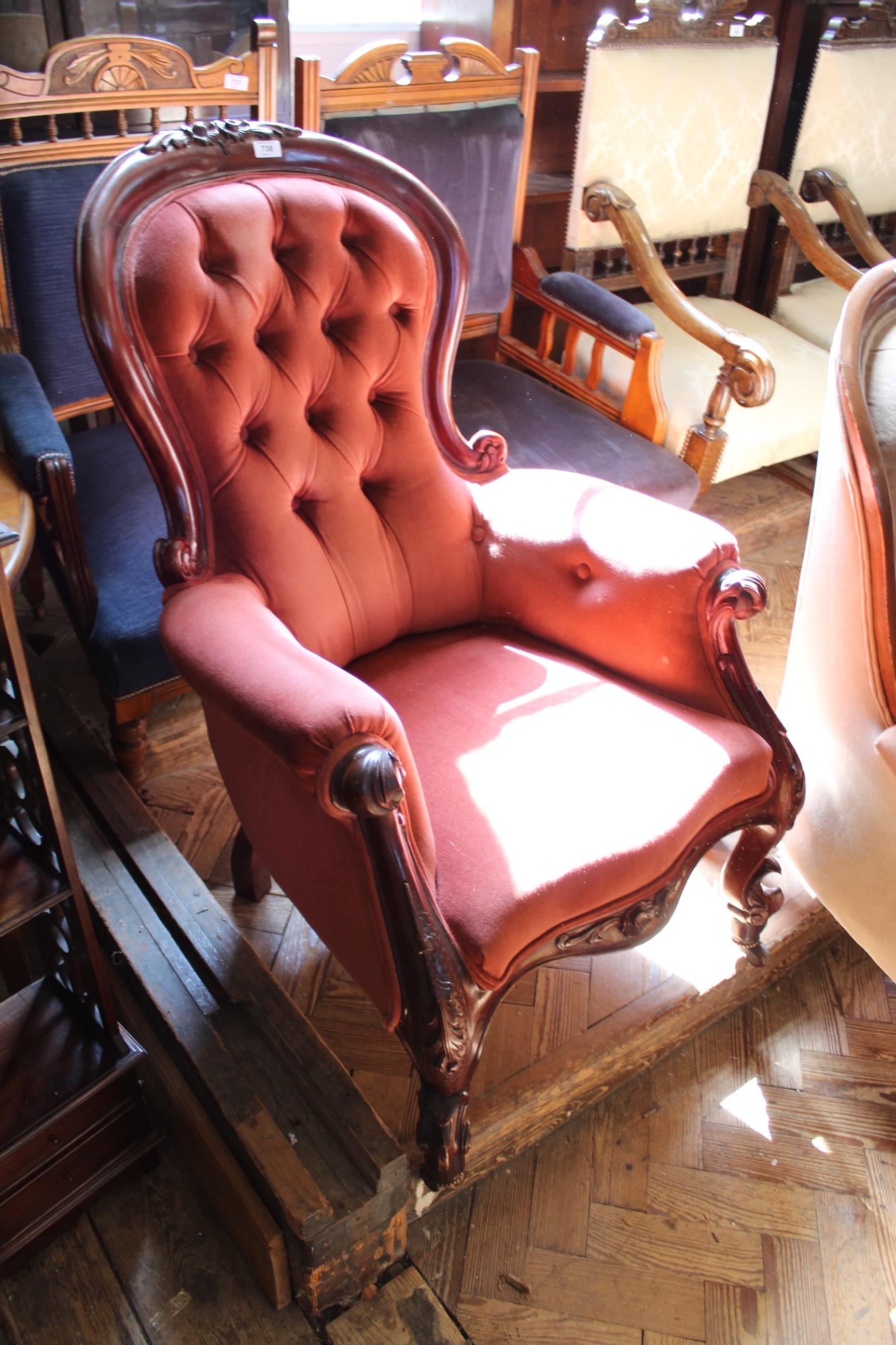 A mid Victorian carved mahogany button back upholstered armchair