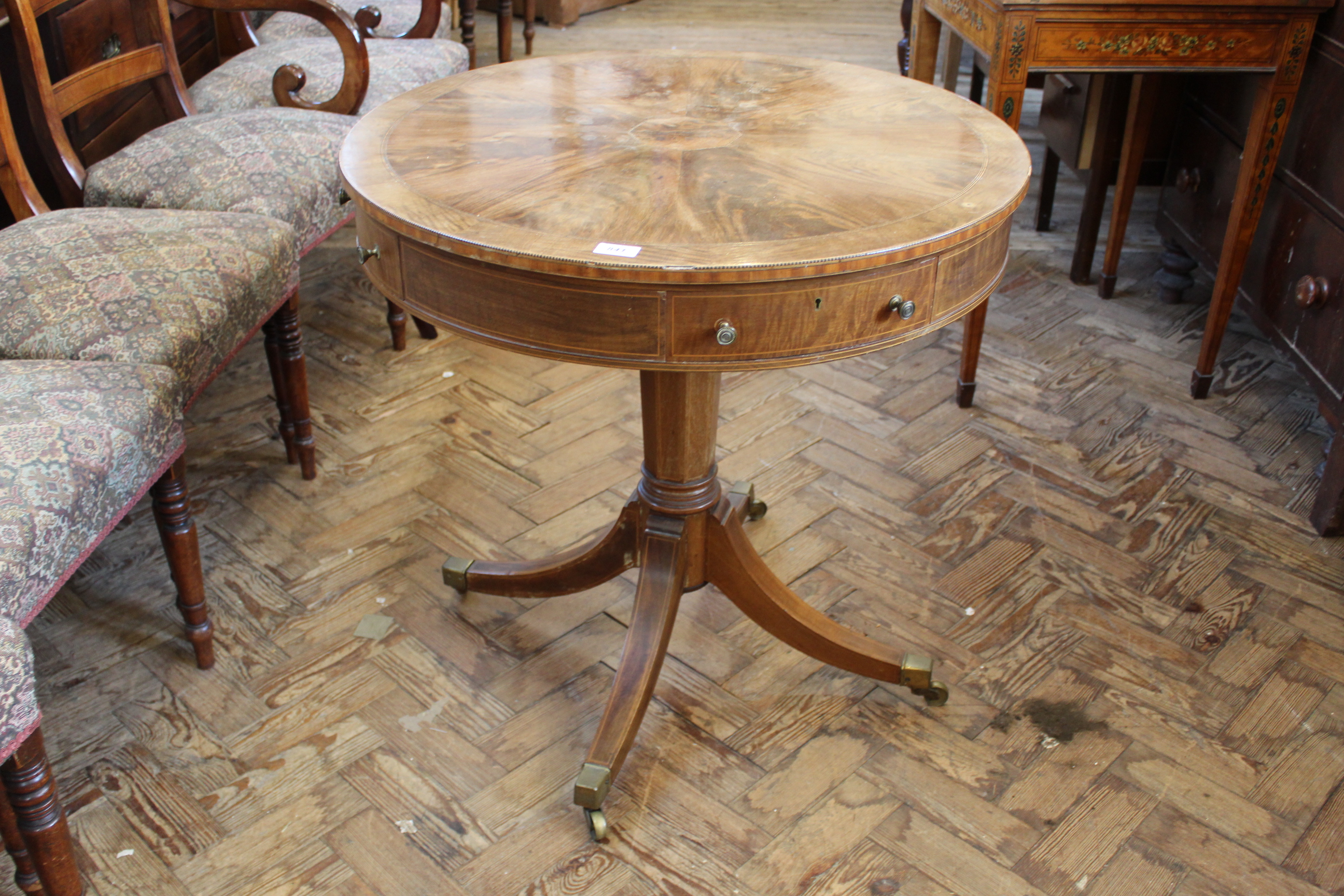 A mahogany inlaid drum table with four drawers in the Sheraton style