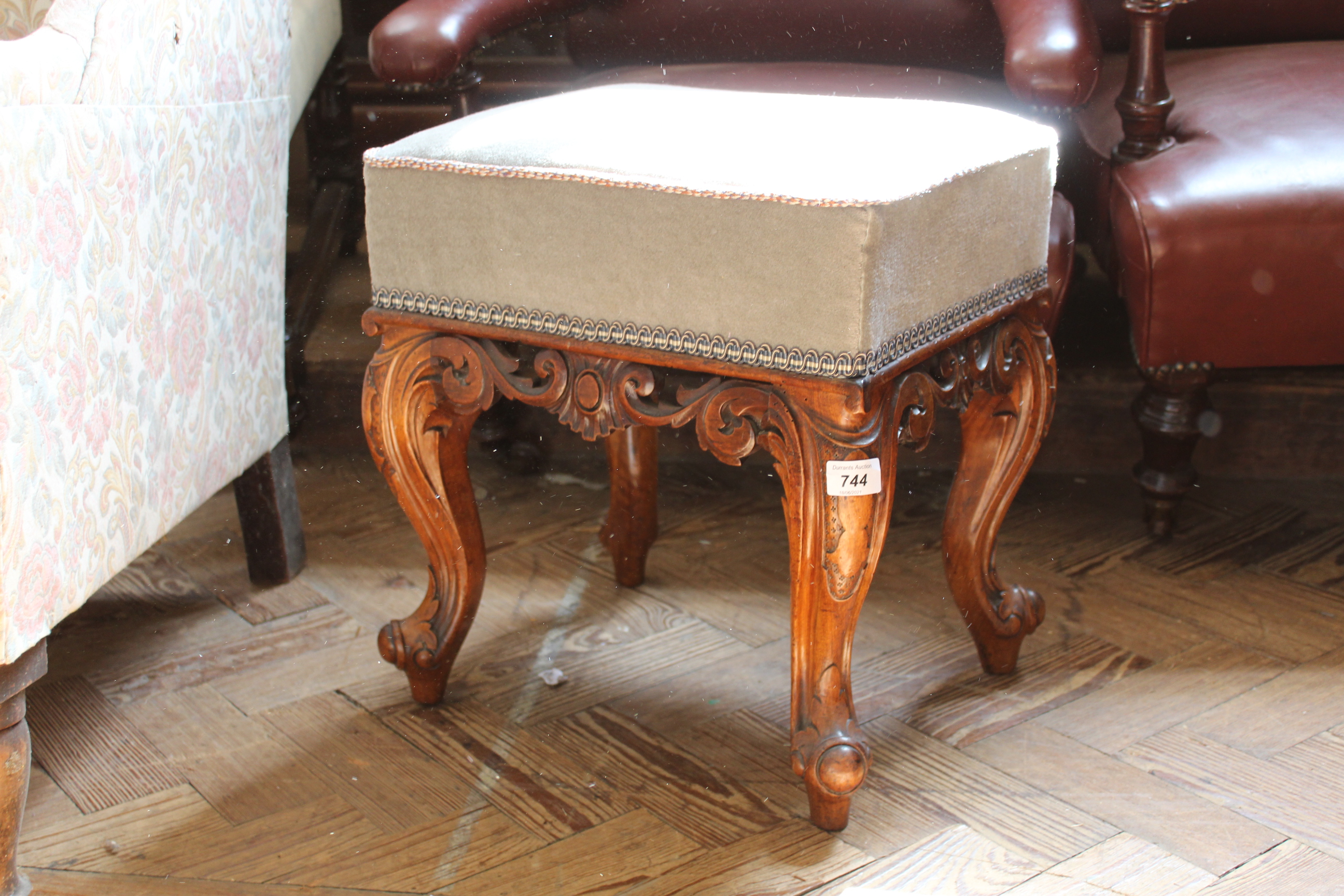 A mid Victorian carved mahogany upholstered stool