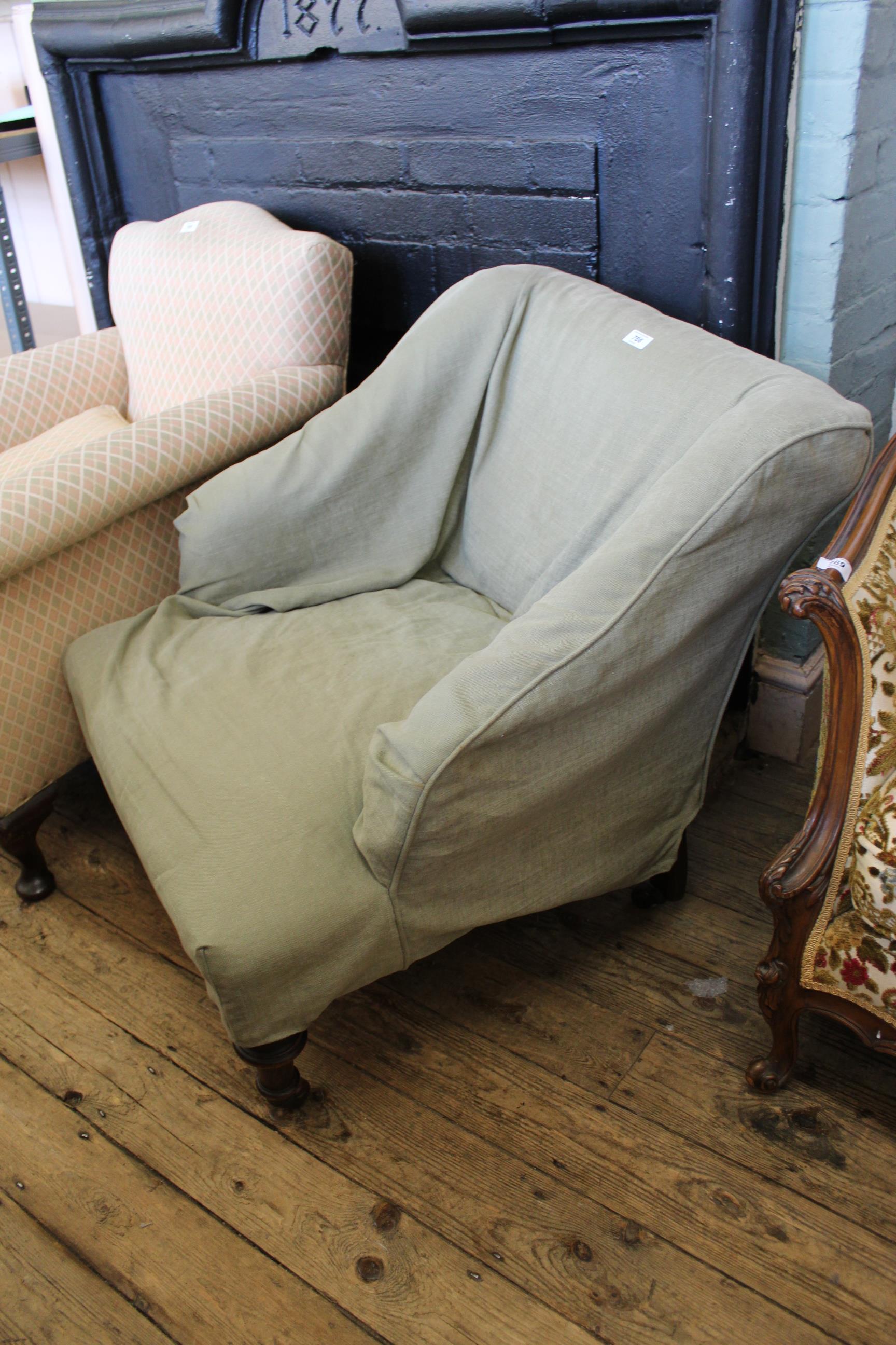A Victorian easy chair on turned cabriole legs and castors