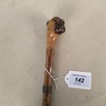 An antique wooden walking stick, the head formed as a mastiff dog with glass eyes,