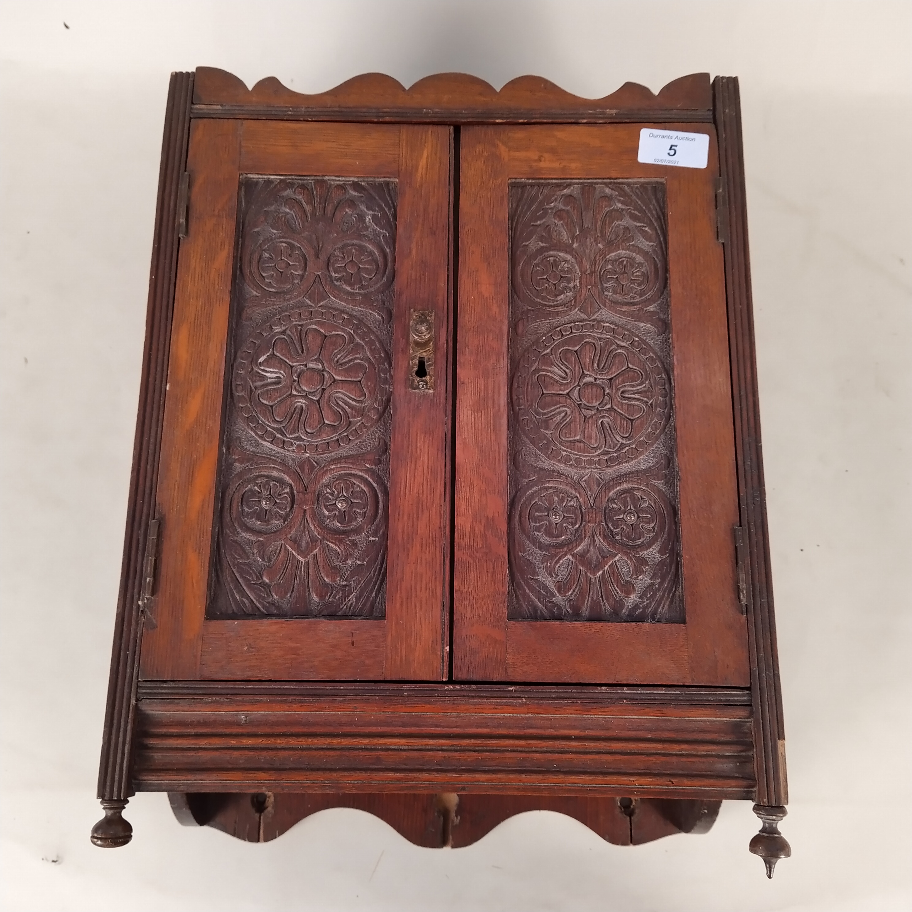 An Edwardian oak cased smokers wall cabinet with contents including two cased Meerschaum pipes