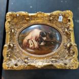 A heavy gilt framed oil on domed wood panel of a Jack Russell with puppies, singed in red,