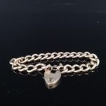 A 9ct gold curb link bracelet with 9ct gold heart shaped padlock clasp (worn),