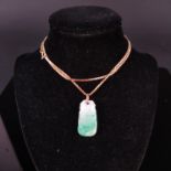 A carved jade pendant on 18ct gold box link chain (stamped 750),