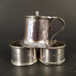 A silver mustard pot (no liner) and two silver napkin rings,