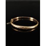 A 9ct gold bangle with foliate decoration (as found),
