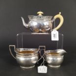 A silver three piece tea set with pierced gallery detail, gilt interior (ivory handle on teapot),