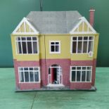 A large hand made wooden dolls house with a selection of furniture,