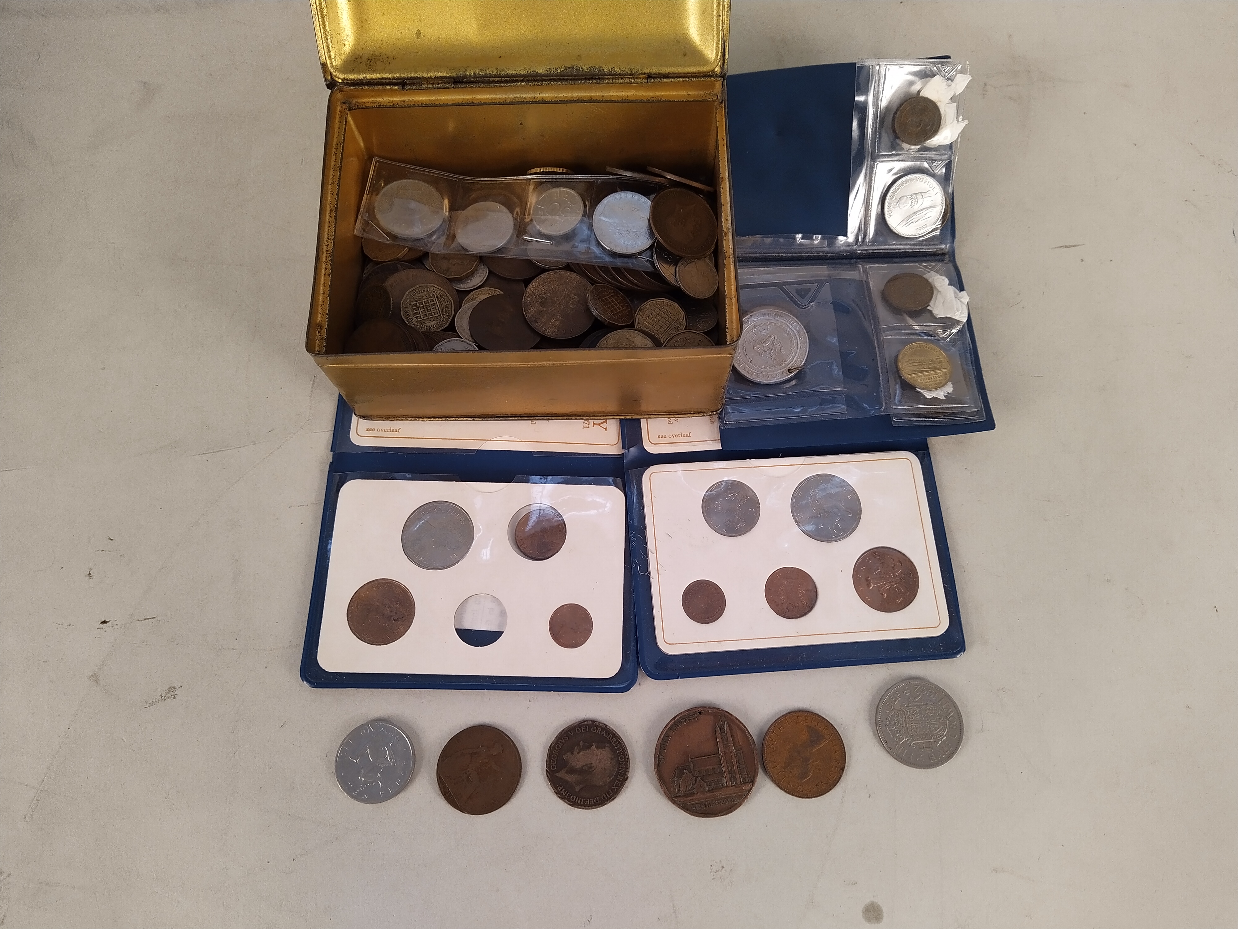 A metal cash tin of mixed coinage,