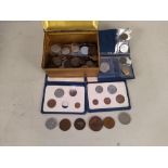 A metal cash tin of mixed coinage,