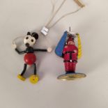 A tin plate Father Christmas whirling figure plus a selection of marbles and a small Mickey Mouse