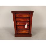 A miniature chest of five drawers with mahogany veneer and ebony stringing,