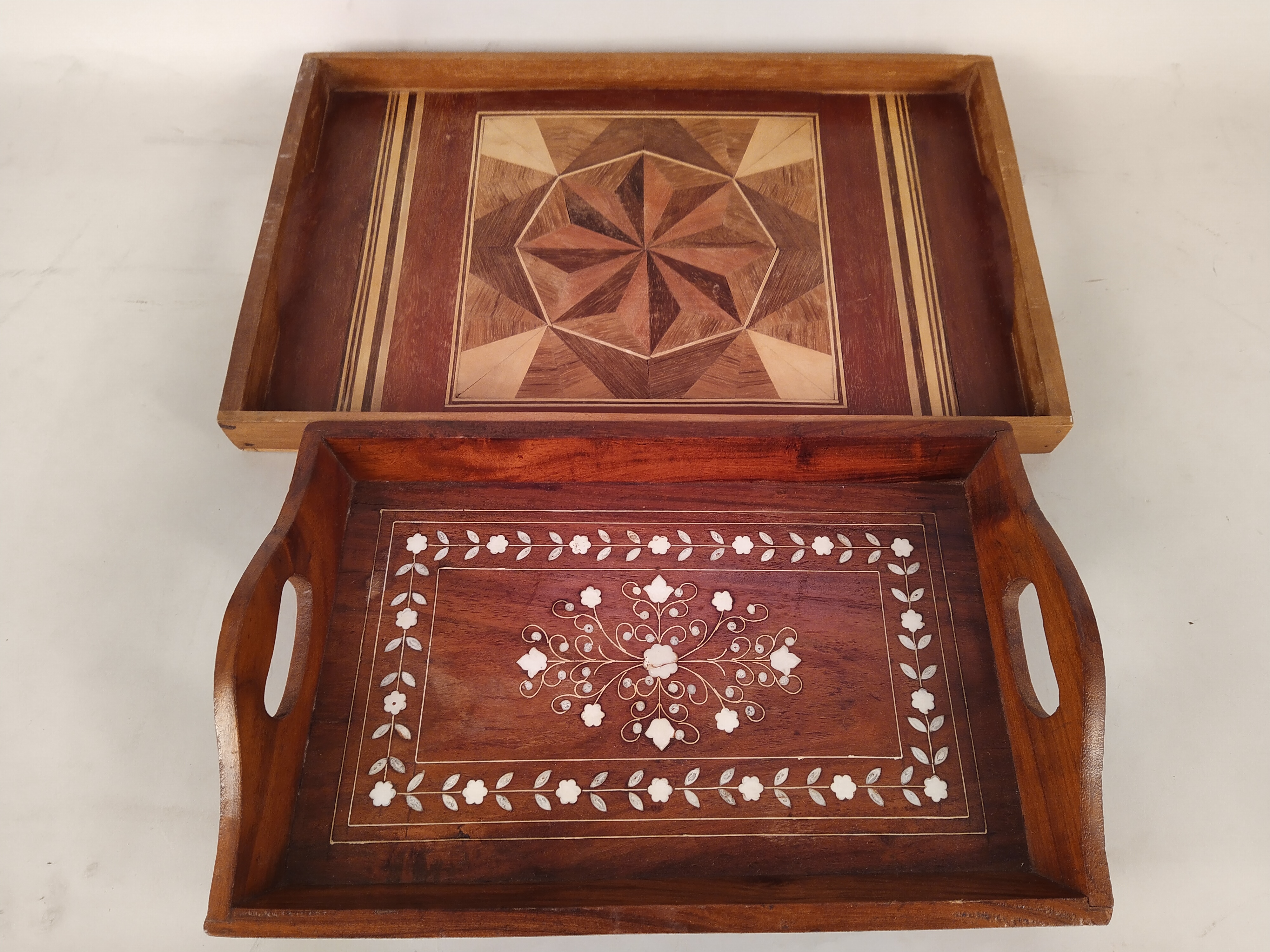 Four vintage inlaid wooden trays, one with flowers,