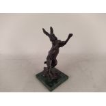 A hollow bronze boxing hare figure on green stone base,