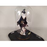 A Japanese porcelain figure of a Geisha under a glass dome,