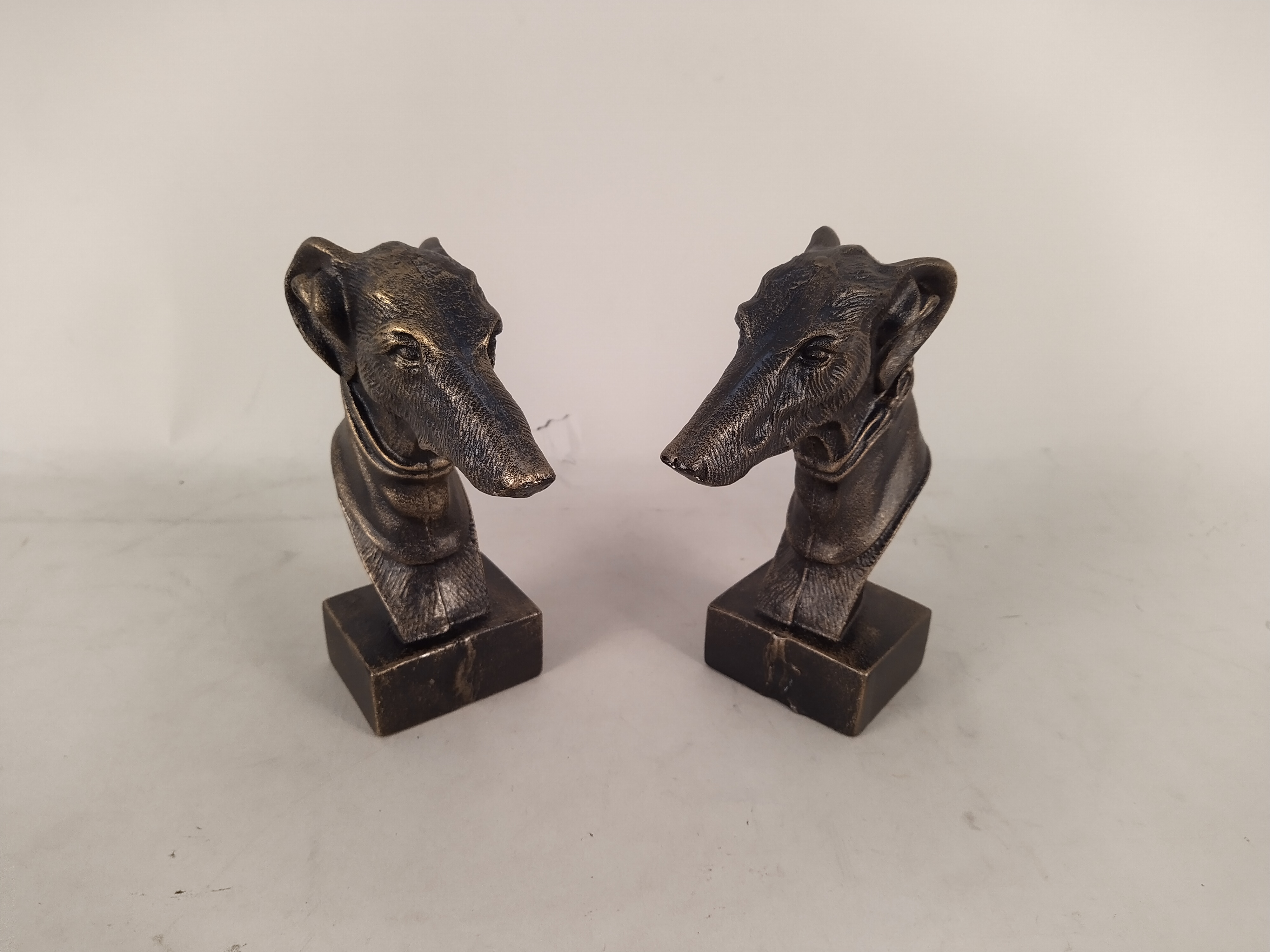 A pair of cast metal greyhound head door stops, a 19th Century oak framed print of Falmouth,