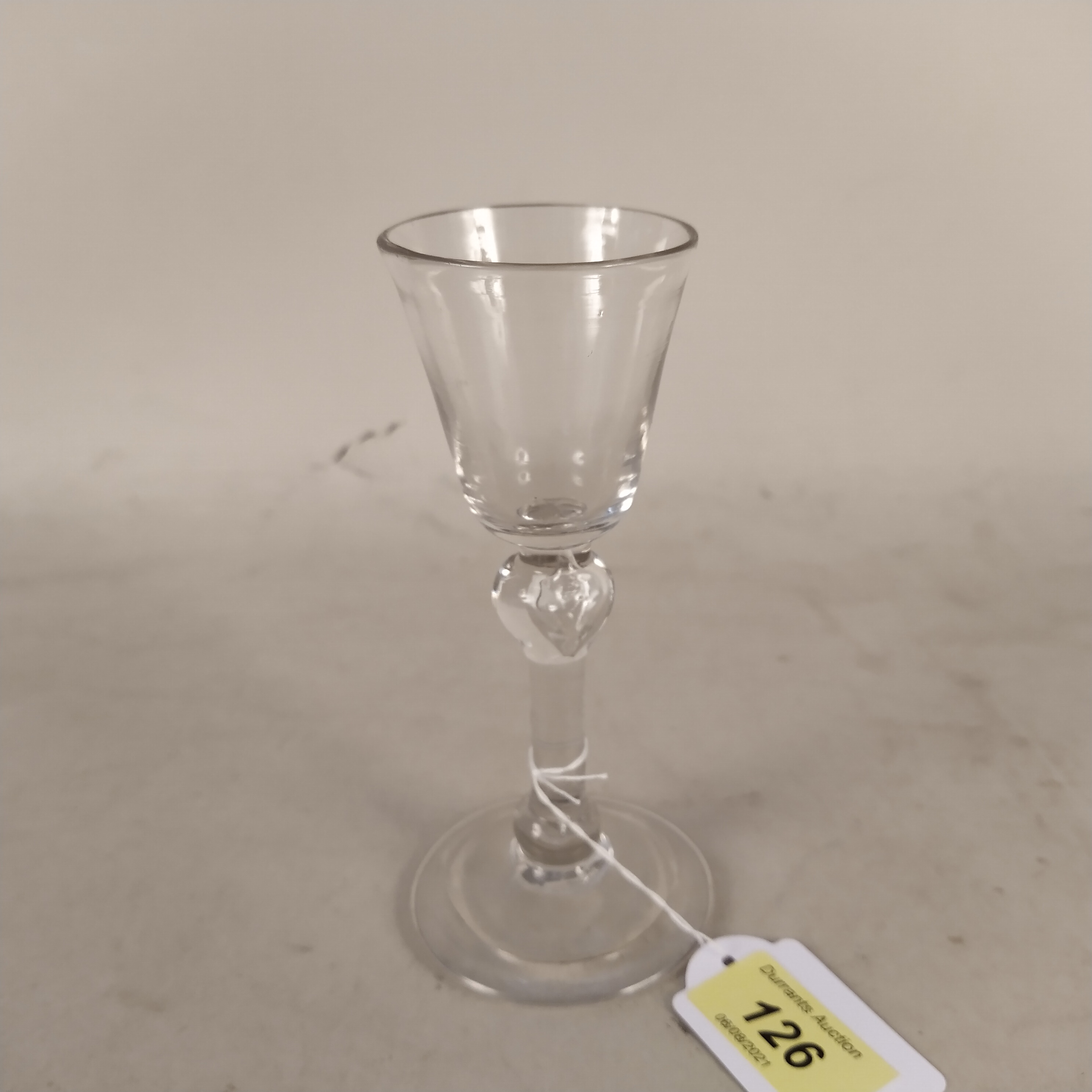 An English wine glass c1740 with ovoid shaped bowl above balustroid stem having recessed shoulder,