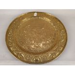 A large embossed brass tray with 17th Century interior scene,