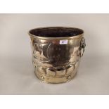 A large 19th Century galleon embossed brass jardiniere or log bucket with lion mask ring handles,