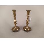A pair of 18th Century Spanish brass candlesticks with knopped stems and shaped seven sided bases