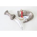 A Saudi Arabian jambiya dagger with white metal embellishment to grip and sheath,