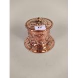An Arts and Crafts cylindrical copper tobacco jar/tea caddy embossed with stylised flowers and