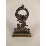 A 19th Century ornately cast brass pocket watch stand depicting a seated lady reading a book