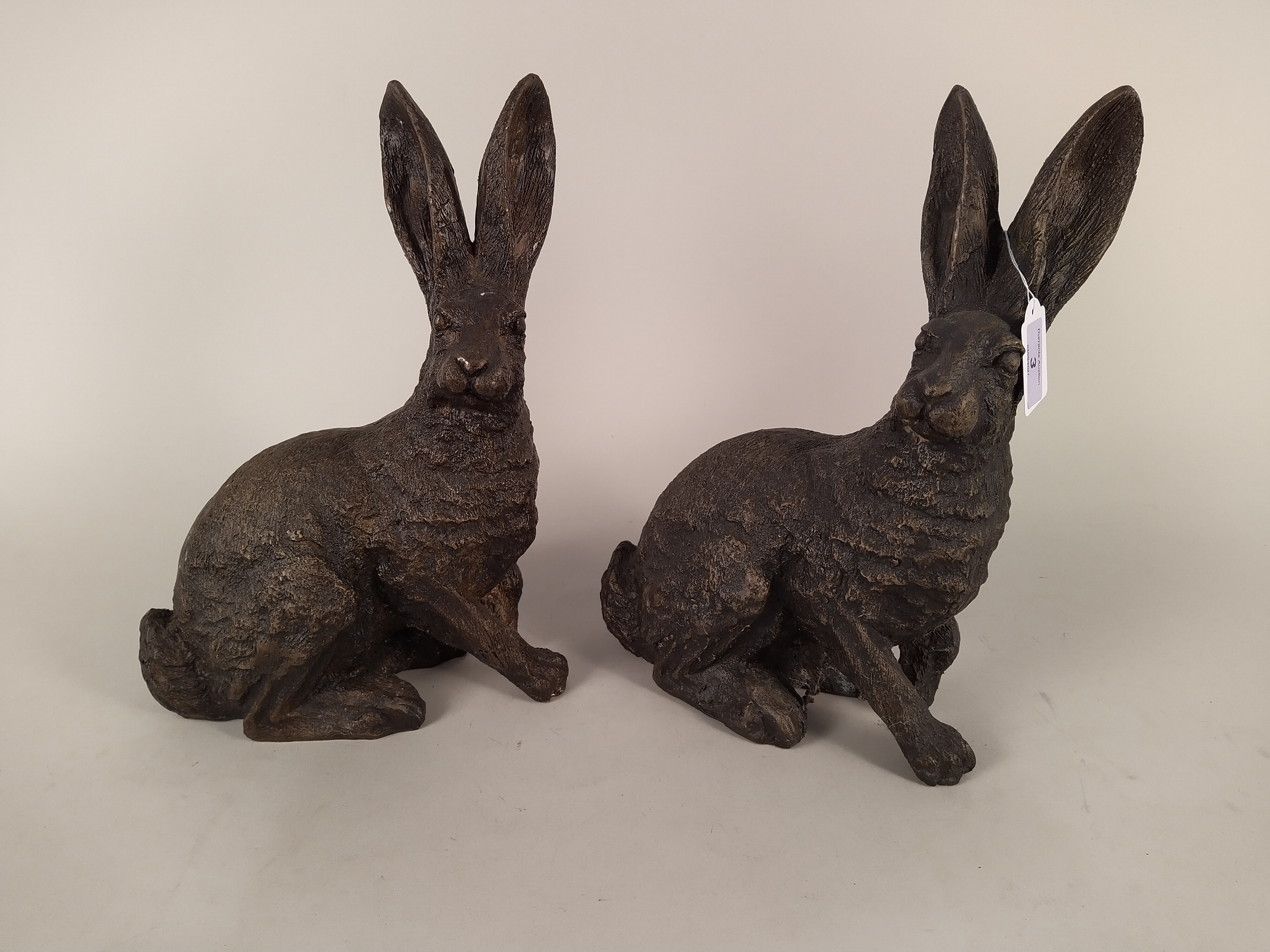 A pair of solid bronze hare figures,