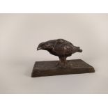 A bronze bird of prey inscribed 'K' in a shield,