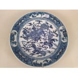 A 19th Century Chinese blue and white charger hand painted with dogs of fo and bats in the border,
