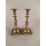 A pair of late 18th Century Spanish brass candlesticks with knopped stems and square bases on four
