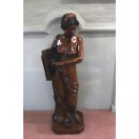 An imposing large statue of a classical lady holding a book constructed from a hand painted