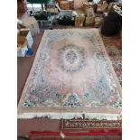 A Chinese wall rug with pink and blue floral panels on a pink ground,