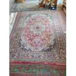 A wool carpet with large central medallion and wide borders in beige and cream on a pink ground