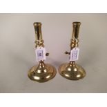 A pair of early 18th Century seamed side ejector brass candlesticks on circular bases,