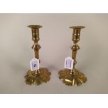 A pair of 18th Century seamed brass candlesticks with knopped stems and petal shaped bases,