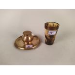 An engraved circular brass inkwell and stand plus a copper rimmed horn beaker